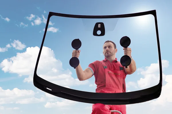 Technicien RideGlass posant un pare-brise neuf avec des ventouses